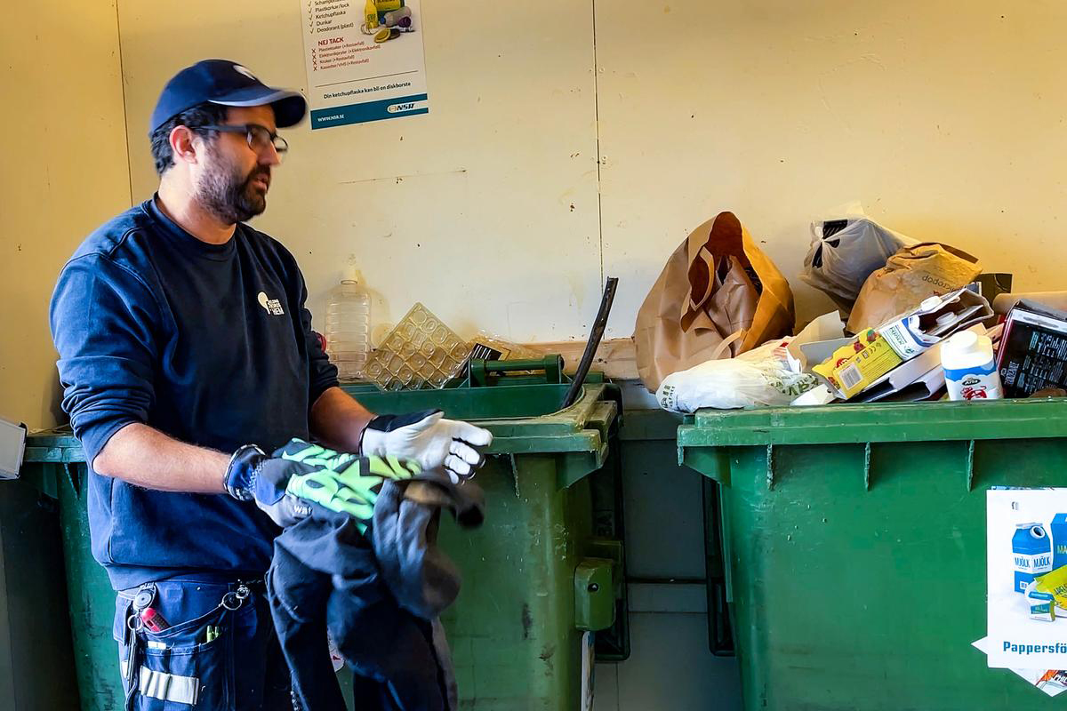 Områdespersonal som sorterar sopor i ett soprum